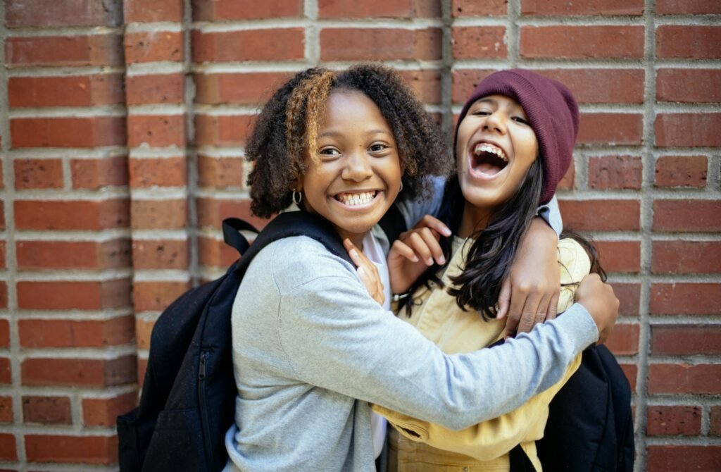 two children after school paying and smiling while embracing