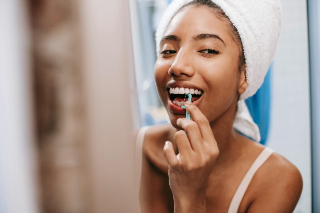 Woman smiling with white teeth while holding floss to her teeth